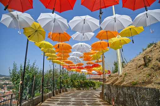 Acri, Italy, 08/04/2021. Colorful umbrellas in a narrow street of an old village in the Calabria region.