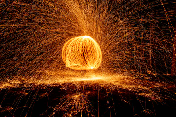 istock Orange circle moving light fire trails on black background. 1335361199