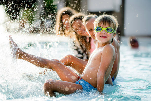 istock Cheerful kids having fun during summer day in the swimming pool 1335362189