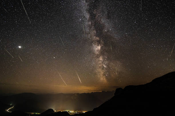 many stars, milky way and perseids on night sky in the mountains over valley Perseid meteor shower. Stacked image of several meteors entering the atmosphere during the perseids. astrophotography with milky way and mountains meteor shower stock pictures, royalty-free photos & images