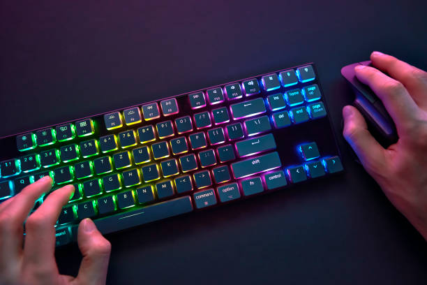 istock Personal point of view on player hands using color backlighted keyboard and mouse. 1335367847