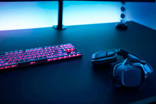 istock Gaming accessories on dark table. Keyboard with color backlit and stereo headphones. 1335368074