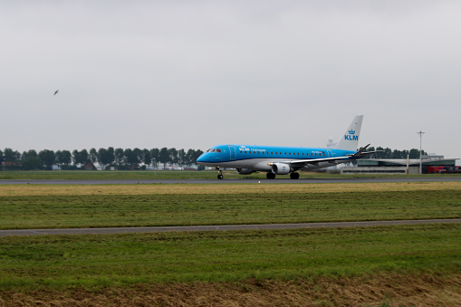 Airplane is departing from PH-EXI KLM Cityhopper Embraer ERJ Polderbaan 18R-36L of Schiphol Amsterdam Airport in the Netherlands