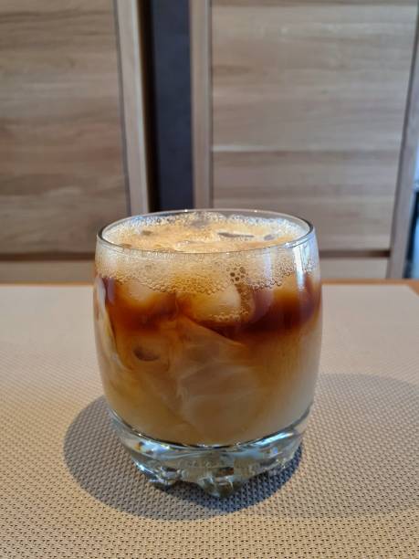 istock Pouring Milk Into Glass With Iced Coffee 1335375572