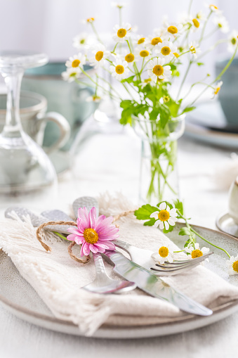 Spring and summer place setting with fresh flowers, cutlery and coffee cup