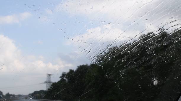 istock Car windshield view of rainfall splashing and dripping 1335376678