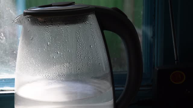 Top and spout of kettle with condensation drops inside