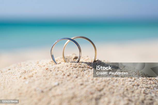 Pair Wedding Rings In Sand On Tropical Beach Stock Photo - Download Image Now - Wedding, Honeymoon, Love - Emotion