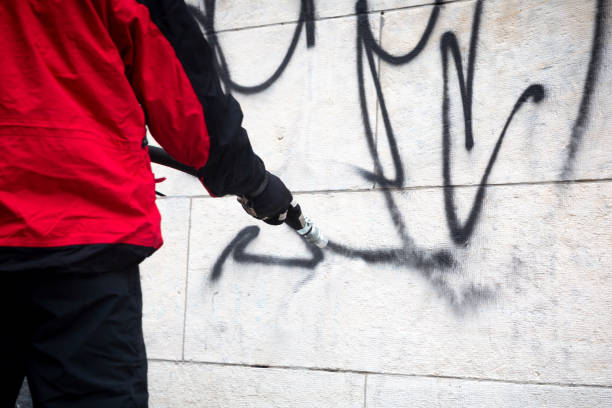 worker cleaning graffiti - vandalism imagens e fotografias de stock