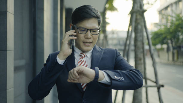 istock Businessman talking on mobile phone checking the time 1335388225
