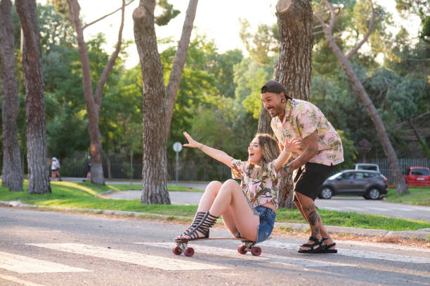 istock Young cool tattooed couple having fun skateboarding. 1335390233