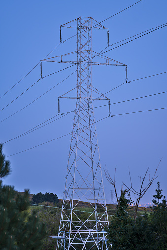 Beautiful early morning view of power lines with electricity transmission pylon captured before sunrise in Ticknock Forest National Park, County Dublin, Ireland. Selective focus