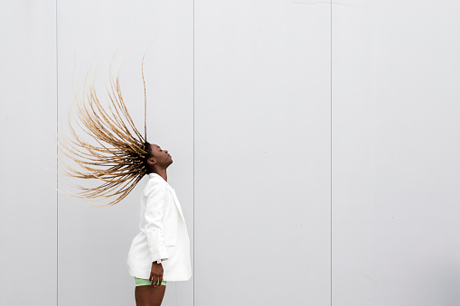 Mujer afroamericana joven que lazo el pelo trenzado rubio largo detrás. Espacio de copia. photo