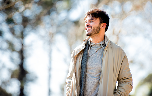 istock Smiling young man out for a walk in a park in the springtime 1335394091