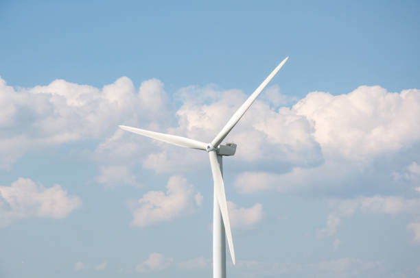 istock Wind turbine against blue sky and clouds background 1335394885