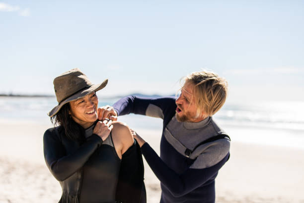 istock Husband helps his wife get her wetsuit on 1335396317