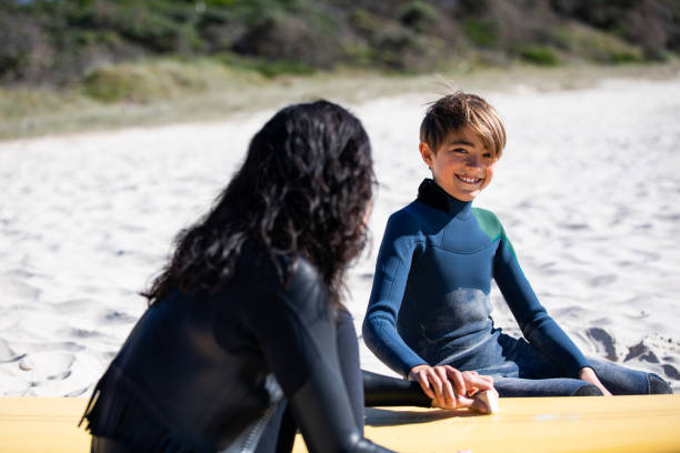 istock Japanese mum and son wax their surfboards together 1335396972