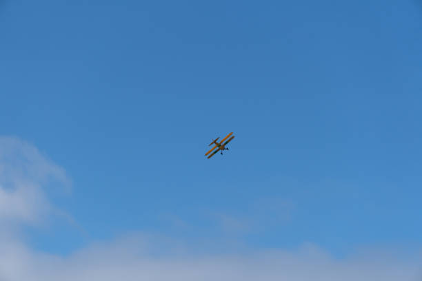 istock Biplane flying with blue sky in background 1335397002