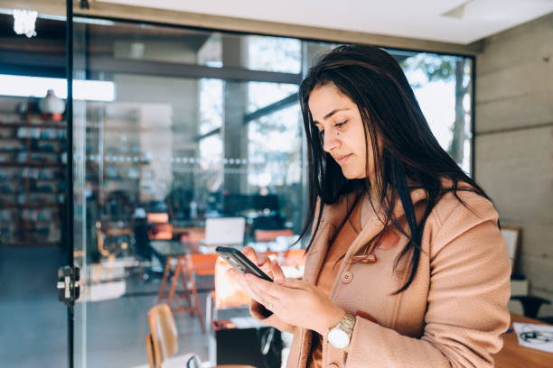 istock Businesswoman using cell phone at the office 1335397196