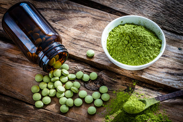 istock Moringa oleifera powder and pills shot on wooden table 1335399954