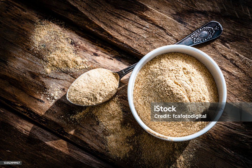 Nutritional supplement: Maca root powder. Copy space Nutritional supplement: Maca root powder in a white bowl shot from above on rustic wooden table. High resolution 42Mp studio digital capture taken with Sony A7rII and Sony FE 90mm f2.8 macro G OSS lens Maca - Herb Stock Photo