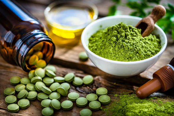 Moringa oleifera powder and pills on rustic table stock photo