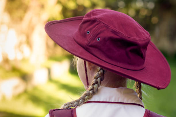 uma garota usando uniforme escolar, camisa branca, mochila marrom e um chapéu de volta à escola. retorno às salas de aula após surto de covid-19 na austrália - australian culture fotos - fotografias e filmes do acervo