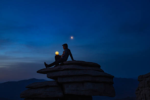 istock A man is holding a lamp under the moon 1335405000