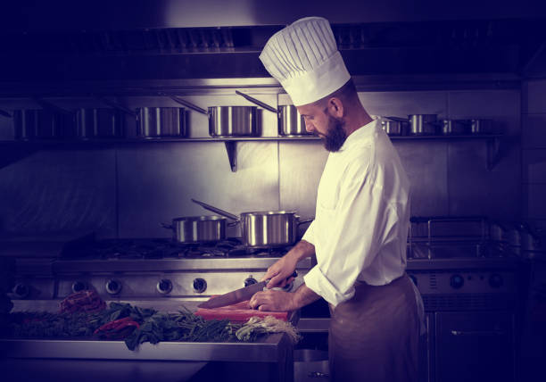 istock Chef cutting meat in restaurant kitchen 1335406075