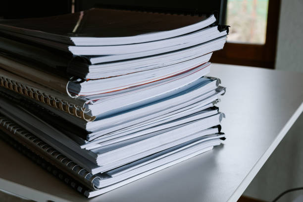 istock Stack of reports lies on a desk ready for review 1335407011