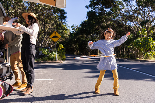 Daughter plays in carpark while mum and dad unload the car