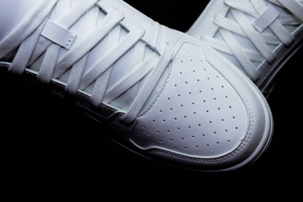 Pair of white sneakers on a black background