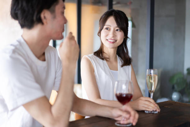 バーでアルコールを飲むカップル - women couple men talking ストックフォトと画像