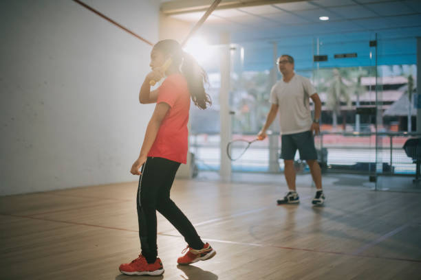 istock young Asian indian female squash player practicing with guidance from her coach 1335419101