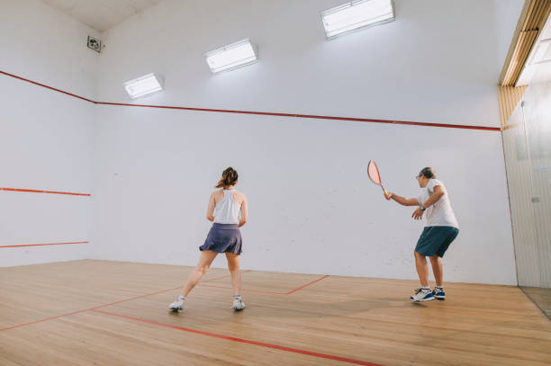 vista lateral entrenador de squash asiático padre guiando a su hija deporte de squash practicando juntos en la cancha de squash - squash racketball sport exercising fotografías e imágenes de stock