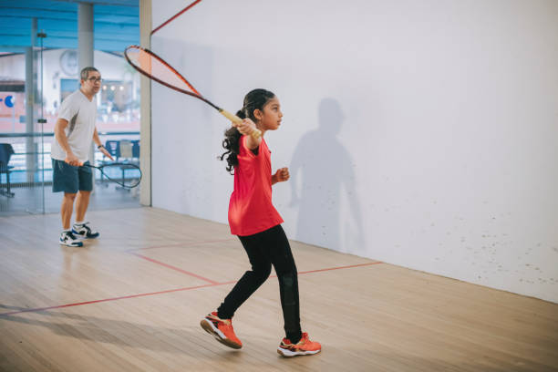 young Asian indian female squash player practicing with guidance from her coach young Asian indian female squash player practicing with guidance from her coach racketball stock pictures, royalty-free photos & images