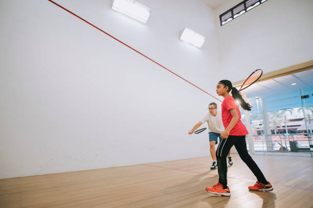 young Asian indian female squash player practicing with guidance from her coach young Asian indian female squash player practicing with guidance from her coach squash sport stock pictures, royalty-free photos & images