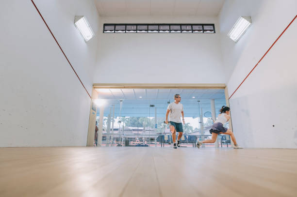 istock front view Asian squash coach father guiding teaching his daughter squash sport practicing together in squash court 1335420308