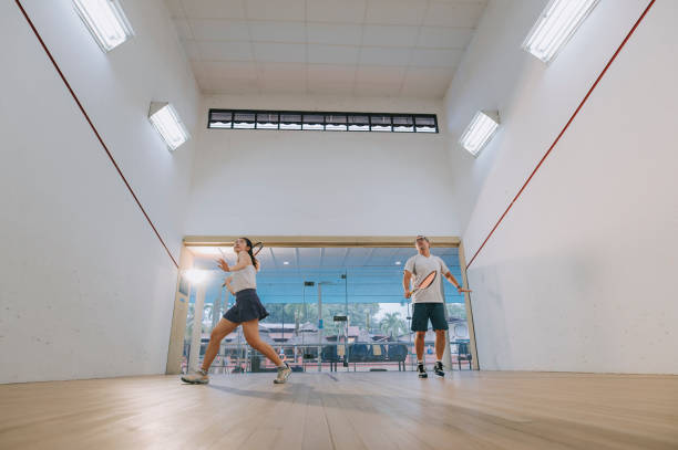 istock front view Asian squash coach father guiding teaching his daughter squash sport practicing together in squash court 1335420315
