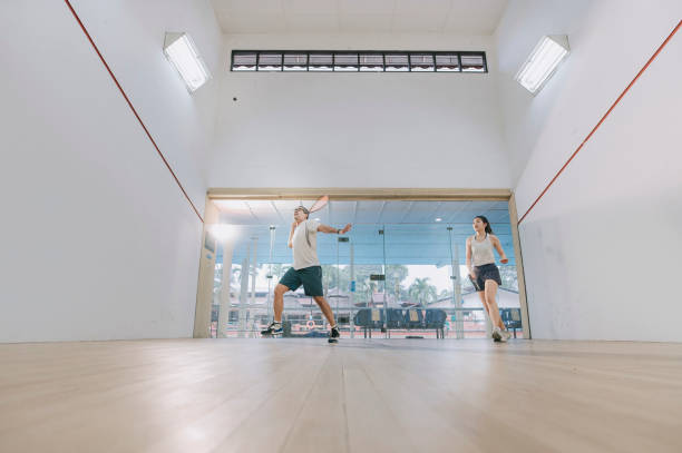 istock front view Asian squash coach father guiding teaching his daughter squash sport practicing together in squash court 1335420332