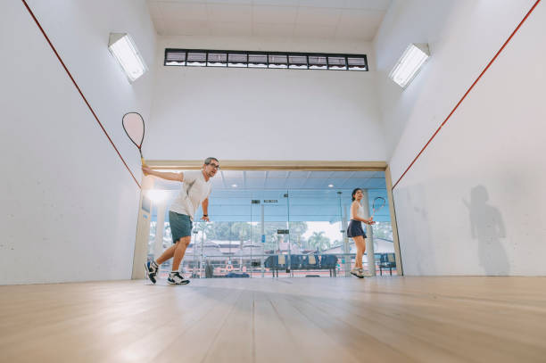 istock front view Asian squash coach father guiding teaching his daughter squash sport practicing together in squash court 1335420333