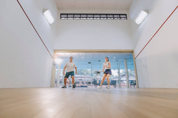 istock front view Asian squash coach father guiding teaching his daughter squash sport practicing together in squash court 1335420343