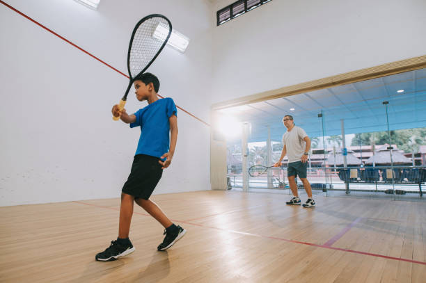 istock young Asian malay male squash player practicing with guidance from his coach 1335420353