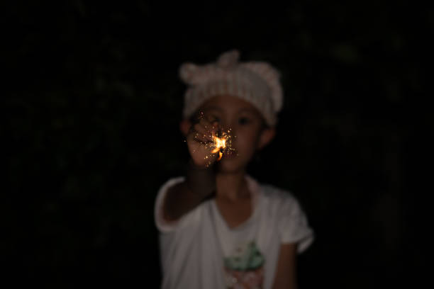istock Girl playing with handheld fireworks 1335420927