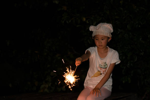 istock Girl playing with handheld fireworks 1335420942