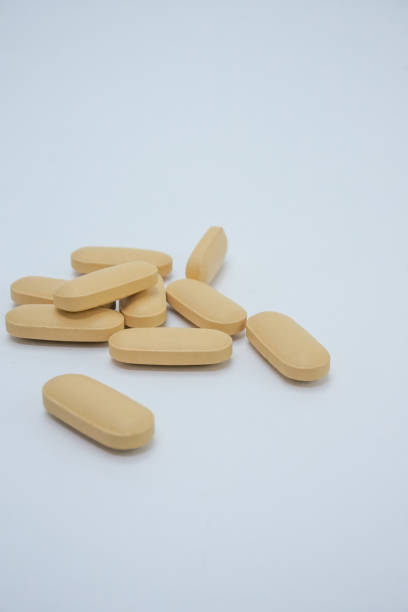 istock Yellow medicine tablet on white background 1335421479