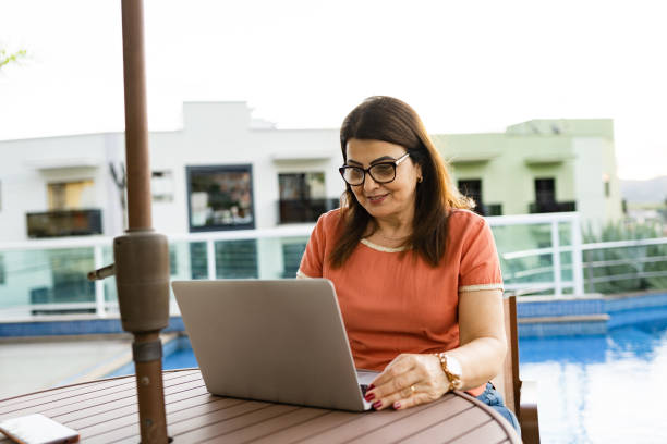 istock Mature woman using laptop at pool table 1335421712