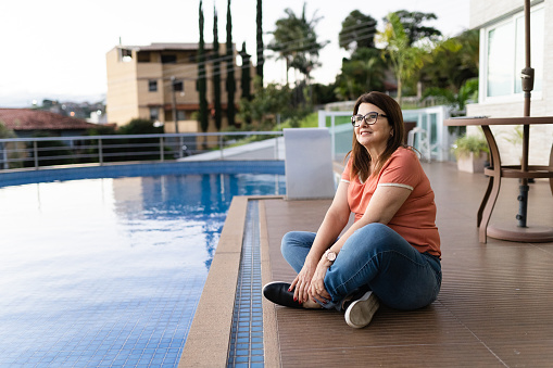 woman sitting on the edge of the pool