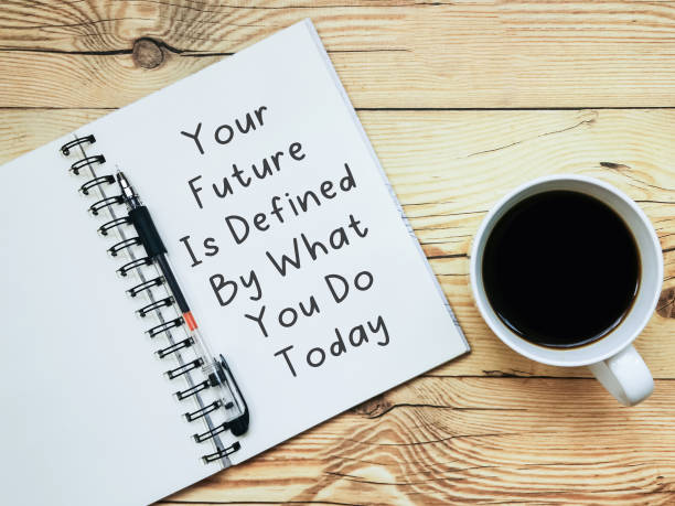 "당신의 미래는 오늘 하는 일에 의해 정의된다"라는 문구가 적고 나무 배경에 커피 한 잔을 들고 노트북을 엽니다. - defined 뉴스 사진 이미지