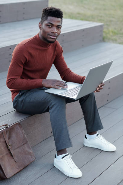 istock Young successful African businessman using laptop 1335426276